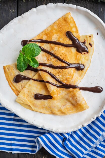 panquecas finas crepes despeje calda de chocolate prato branco bolo raso lanche