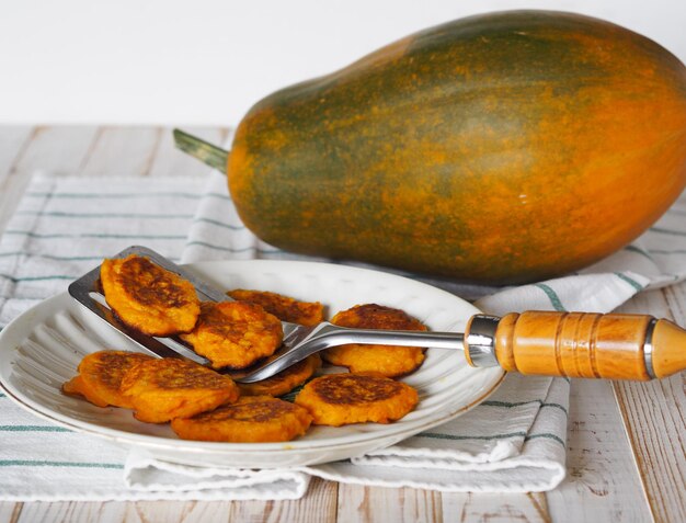 Panquecas naturais de abóbora e milho em uma mesa branca de madeira com fundo de comida de outono