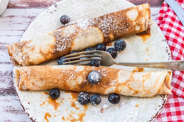 panquecas ou crepes caseiros recheados com doce de leite e mirtilos e cobertura de açúcar de confeiteiro