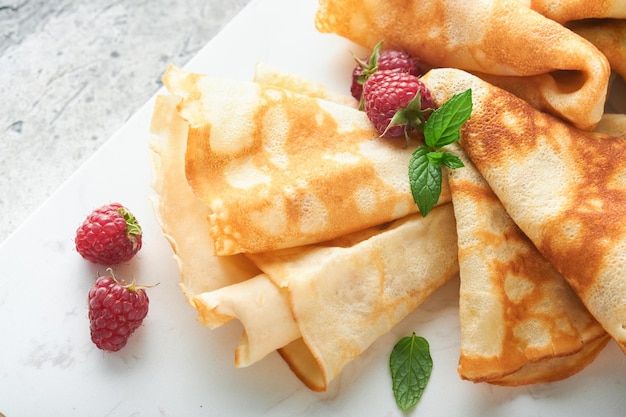 Panquecas Pilha de crepes ou panquecas finas com frutas vermelhas com framboesas e mel no café da manhã O dia da panqueca é um conceito tradicional de feriado americano ou inglês Café da manhã caseiro Foco seletivo