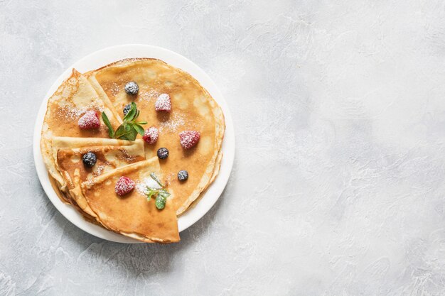 Panquecas russas ou blini com frutas em chapa branca. primavera. entrudo.