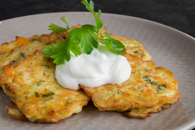 Foto panquecas vegetarianas de abobrinha saudáveis com ervas e creme de leite