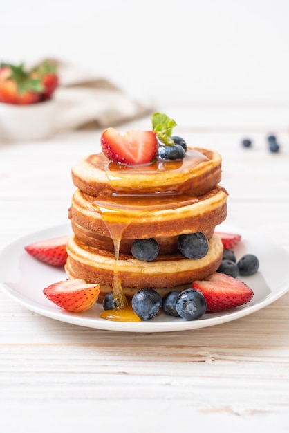 panqueque con arándanos frescos, fresas frescas y miel