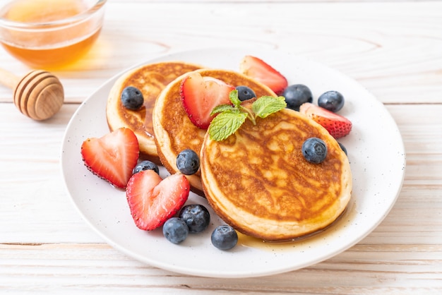 panqueque con arándanos frescos, fresas frescas y miel