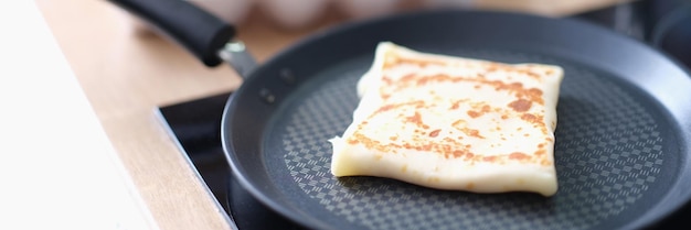 Panqueque doblado en sartén con fondo de huevos de gallina en la cocina