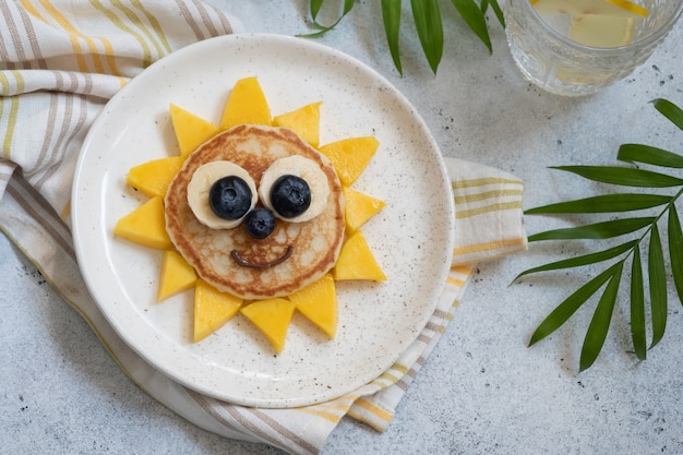 Panqueque de flores divertidas con desayuno de frutas