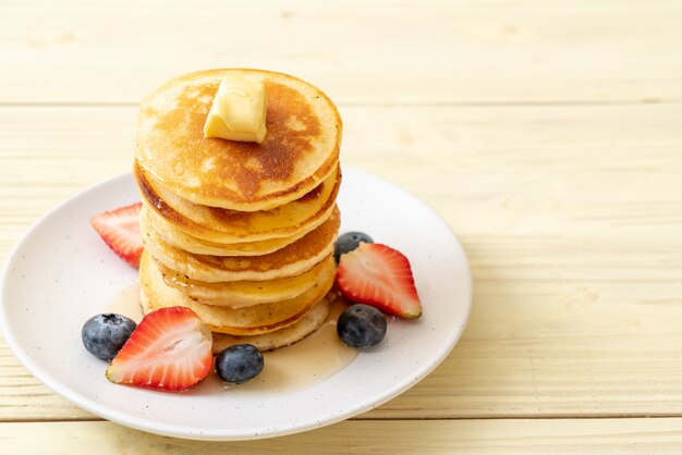 panqueque con fresas, arándanos y miel