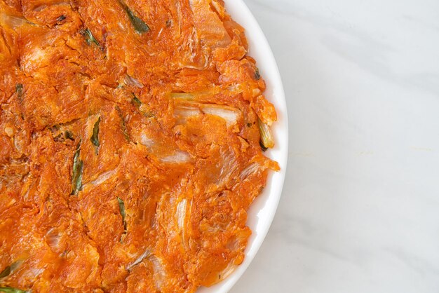 Panqueque de kimchi coreano o kimchijeon - huevo frito, kimchi y harina - estilo de comida coreana