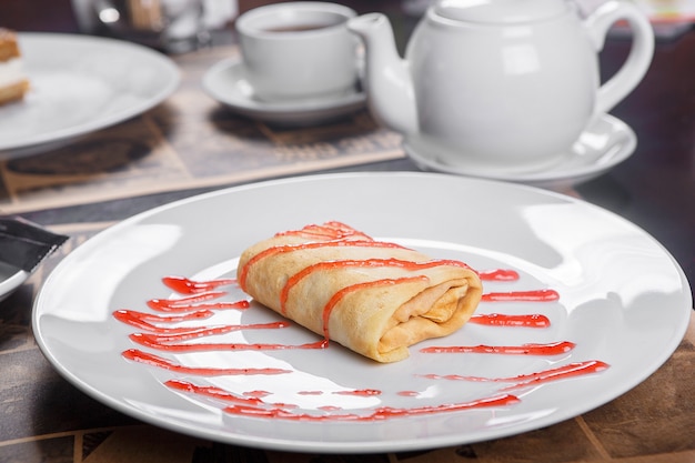 Panqueque relleno en un plato con mermelada