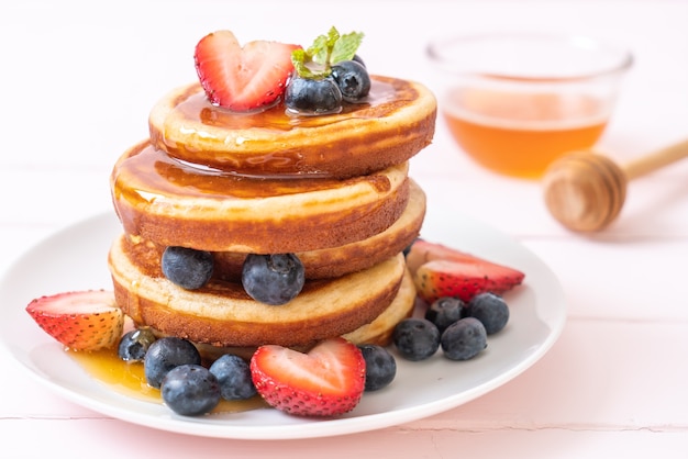 panqueque soufflé con arándanos frescos, fresas frescas y miel