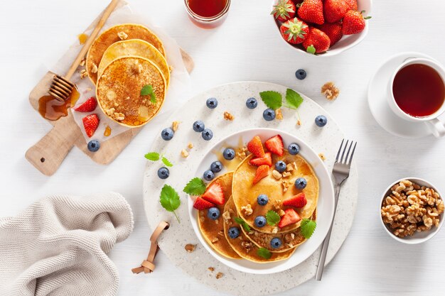 Panqueques con arándanos, fresas, miel y nueces para el desayuno