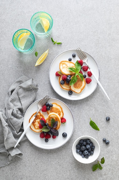 Panqueques con arándanos frescos y frambuesas servidos para un desayuno vegetariano saludable