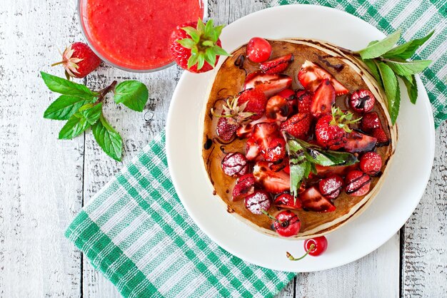 Panqueques con bayas y batido de fresa en un estilo rústico