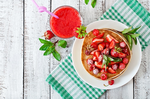 Panqueques con bayas y batido de fresa en un estilo rústico