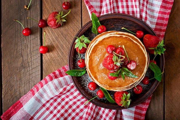 Panqueques con bayas y jarabe en un estilo rústico