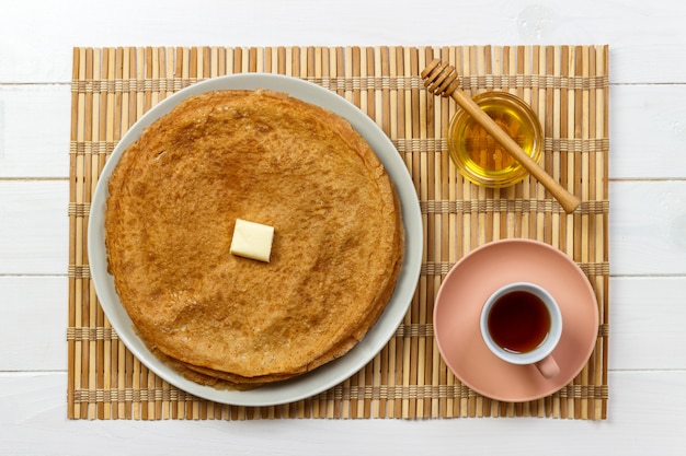 Panqueques calientes con mantequilla y miel en un plato