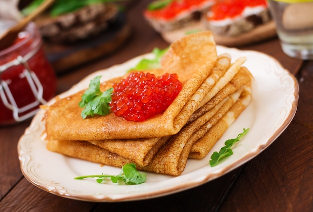 Panqueques con caviar rojo en la placa. Cocina rusa. Maslenitsa