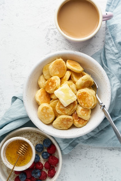 Panqueques de cereales, bollos finos y divertidos, comida para niños. Desayuno con bebida