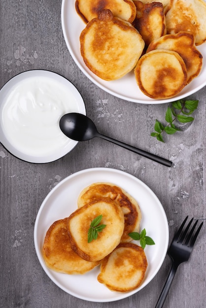 Panqueques con crema agria sobre una mesa de madera gris