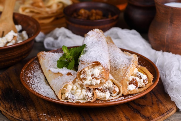 Foto panqueques delgados rellenados con queso cottage, miel y pasas