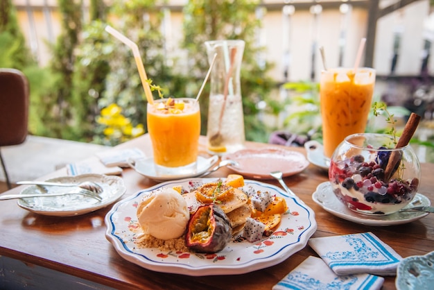 Panqueques dulces con miel y helado de vainilla Frutas con enfoque naranja en panqueque