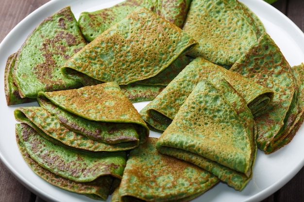 Panqueques con espinacas en plato blanco. Fondo de desayuno