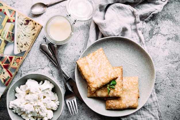 Panqueques finos con hierbas, salmón y queso crema en un plato