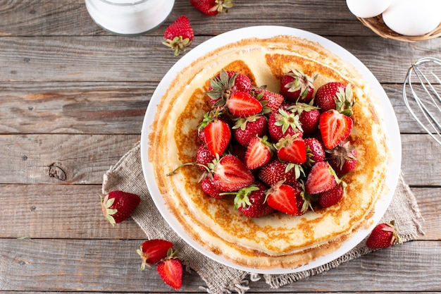 Panqueques con fresa, tradicional para el martes de carnaval en mesa de madera. Vista superior. Copia espacio