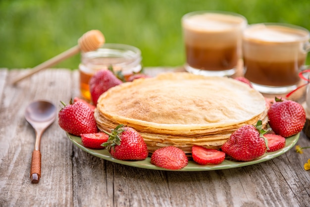 Panqueques con fresas y café para el desayuno.