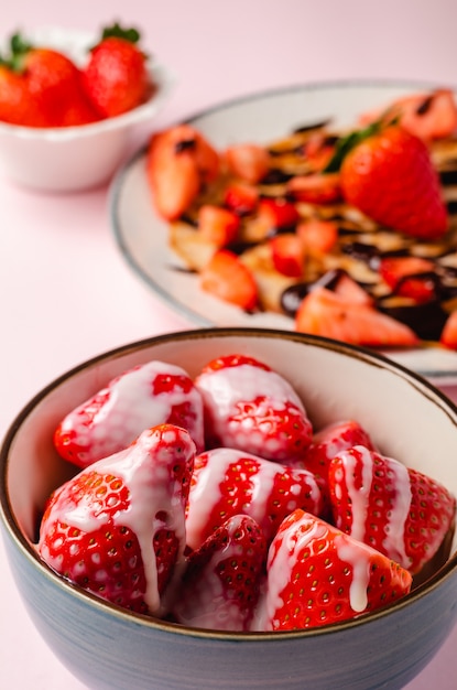 Panqueques con fresas frescas en una pared de madera azul