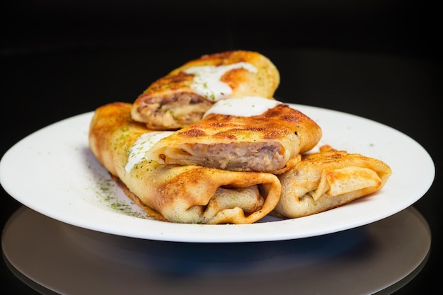 Panqueques fritos delgados con carne en un plato con crema agria y especias comida ucraniana