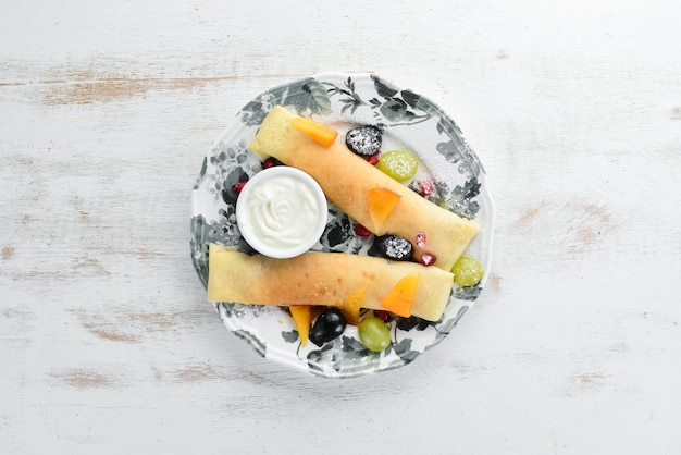 Panqueques con fruta y crema agria Postre Sobre un fondo de madera Vista superior Espacio libre para su texto