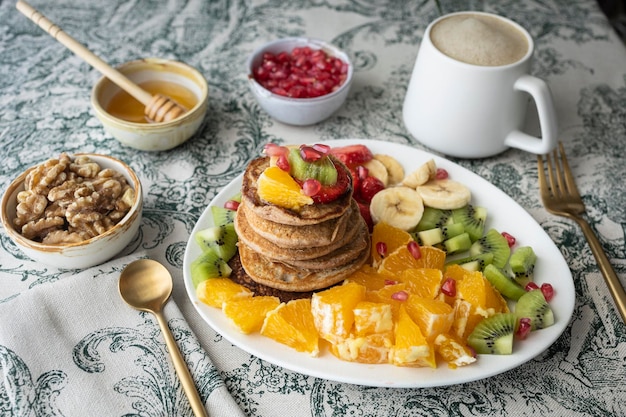 Panqueques con fruta fresca. Ensalada de frutas con tortitas sin gluten. Desayuno saludable lleno de vitaminas