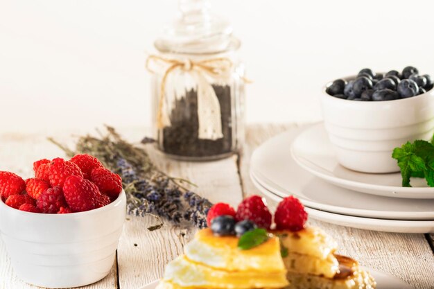 Panqueques con frutas del bosque bayas en mesa blanca