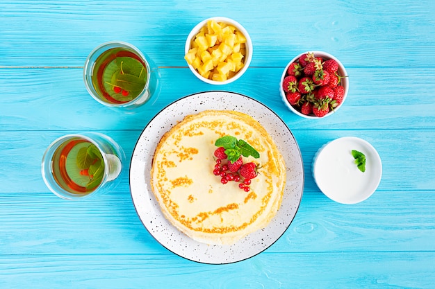 Panqueques con manzanas caramelizadas, frambuesas, fresas y grosellas rojas