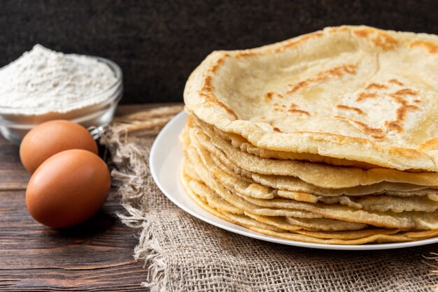 Panqueques en mesa de madera con ingredientes al lado