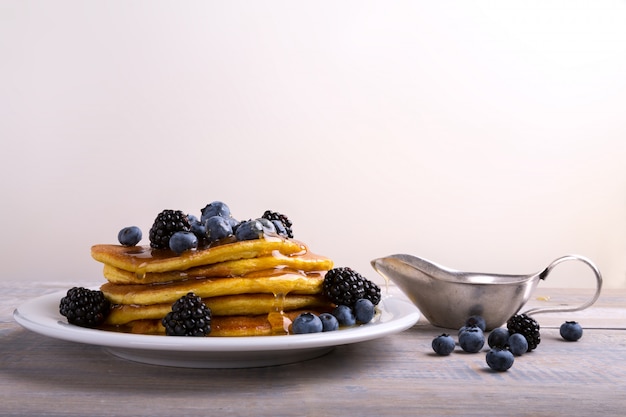 panqueques con moras, arándanos y jarabe de arce.