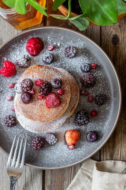 Panqueques con moras, frambuesas y grosellas rojas. Cocina americana.