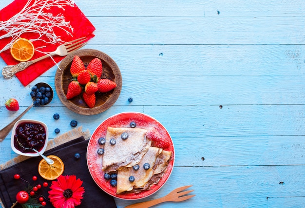 Foto panqueques o crepes de fresas frescas con bayas y chocolate