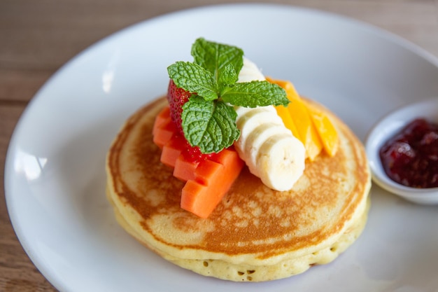 Panqueques con plátano, mango, menta y mermelada de fresa para el desayuno