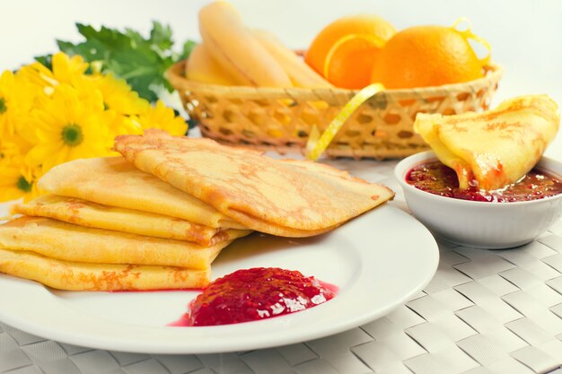 Panqueques en un plato blanco con mermelada de frambuesa