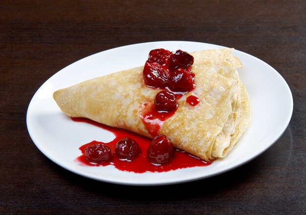 Panqueques en plato con confitura de cerezas dulces