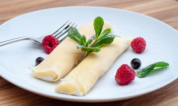 Panqueques en un plato con frutas del bosque