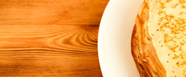 panqueques en un plato sobre una mesa de madera una gran pila de panqueques frescos