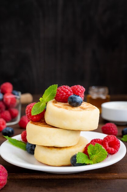 Panqueques de queso cottage con bayas frescas crema agria y miel Syrniki casero