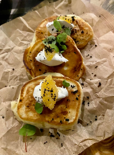 Panqueques con queso con crema de caviar y hierbas en un fondo de papel ecológico Craft