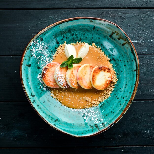 Panqueques de queso con helado de caramelo y nueces Desayuno En el plato Vista superior Composición plana Espacio de copia libre