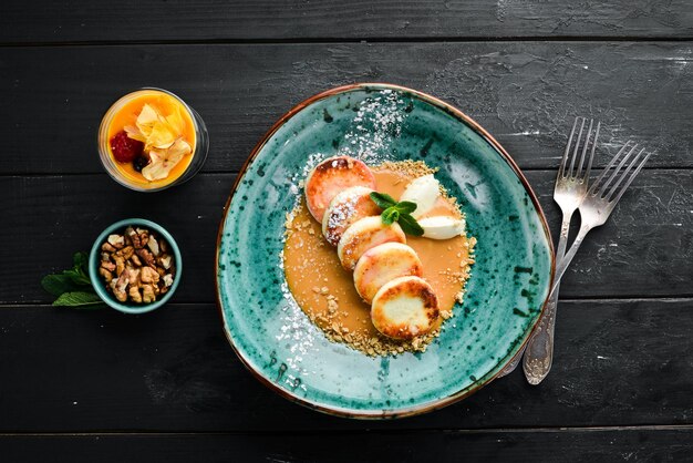 Panqueques de queso con helado de caramelo y nueces Desayuno En el plato Vista superior Composición plana Espacio de copia libre