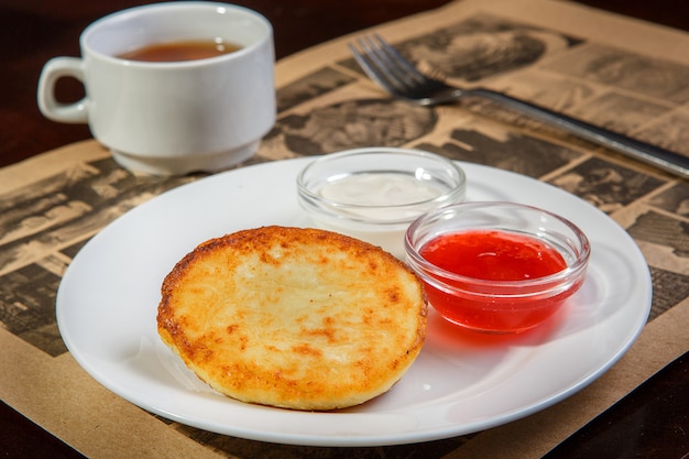 Panqueques De Queso En Un Plato Con Crema Agria Y Mermelada