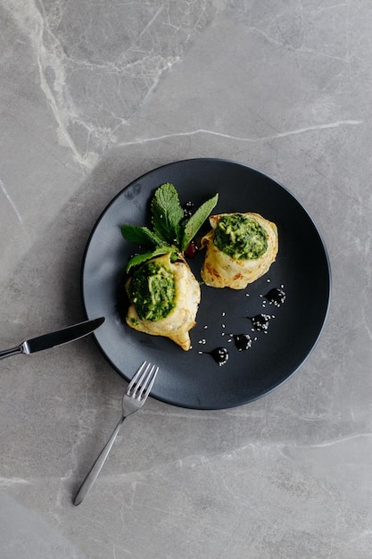 Panqueques rellenos de espinacas Desayuno saludable sobre fondo gris Copiar espacio